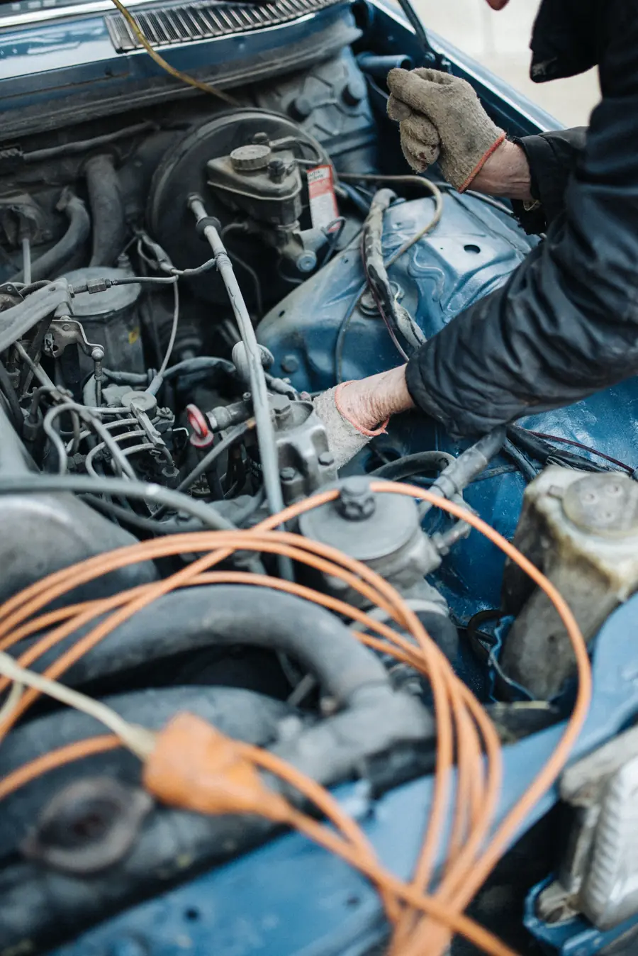 Mâinile unui mecanic lucrând în compartimentul motor al unei mașini